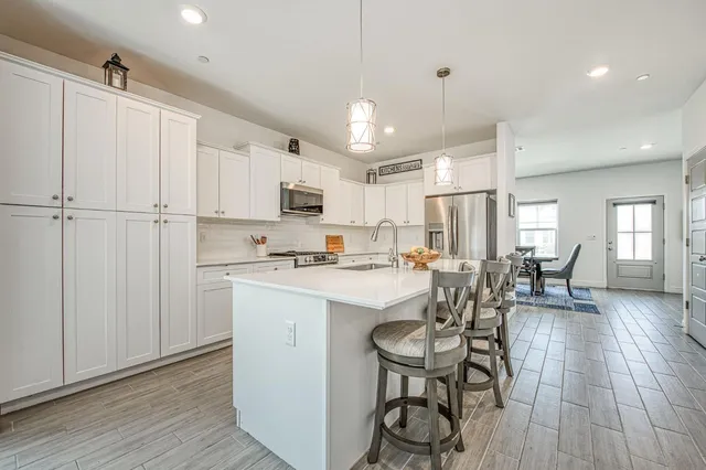 a kitchen with kitchen island a sink stove and wooden floor