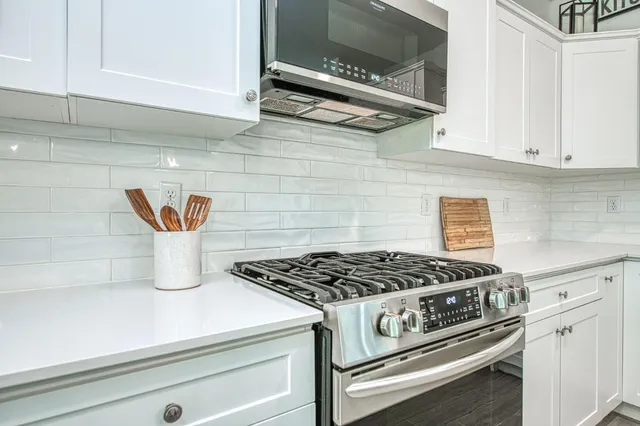 a living room with furniture a large window and wooden floor