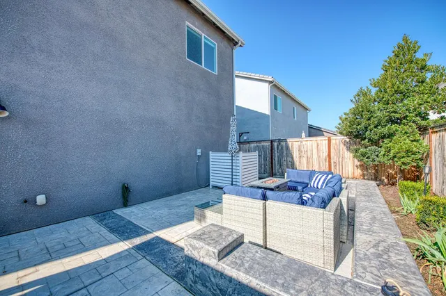 a patio with glass top table and chairs