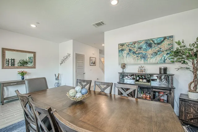 a kitchen with stainless steel appliances granite countertop a stove top oven a sink dishwasher a dining table and chairs with wooden floor