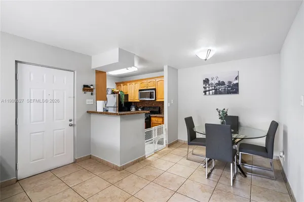 a kitchen with white cabinets and chairs