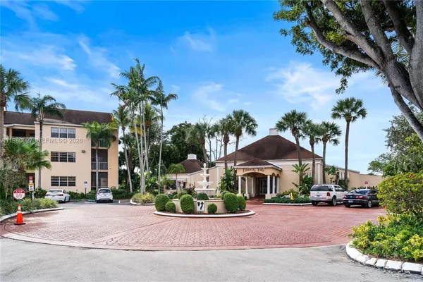 a front view of multi story residential apartment building with yard and green space