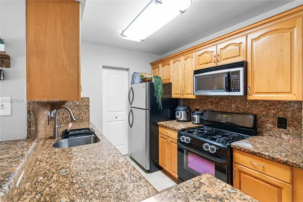 a kitchen with stainless steel appliances granite countertop a stove refrigerator and microwave