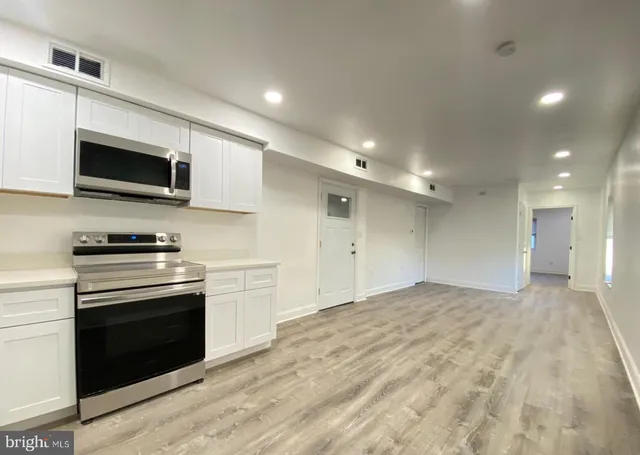 a kitchen with granite countertop a stove and a microwave