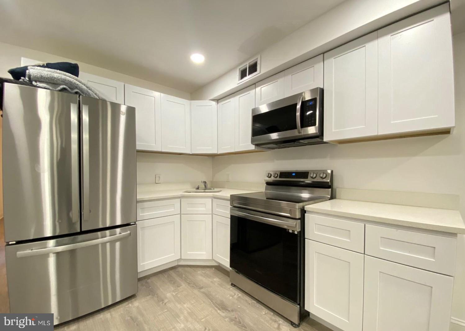 1230 North 15th Street Philadelphia, PA 19121 - Photo 3 of 31 a kitchen with stainless steel appliances granite countertop a refrigerator stove a sink and a microwave
