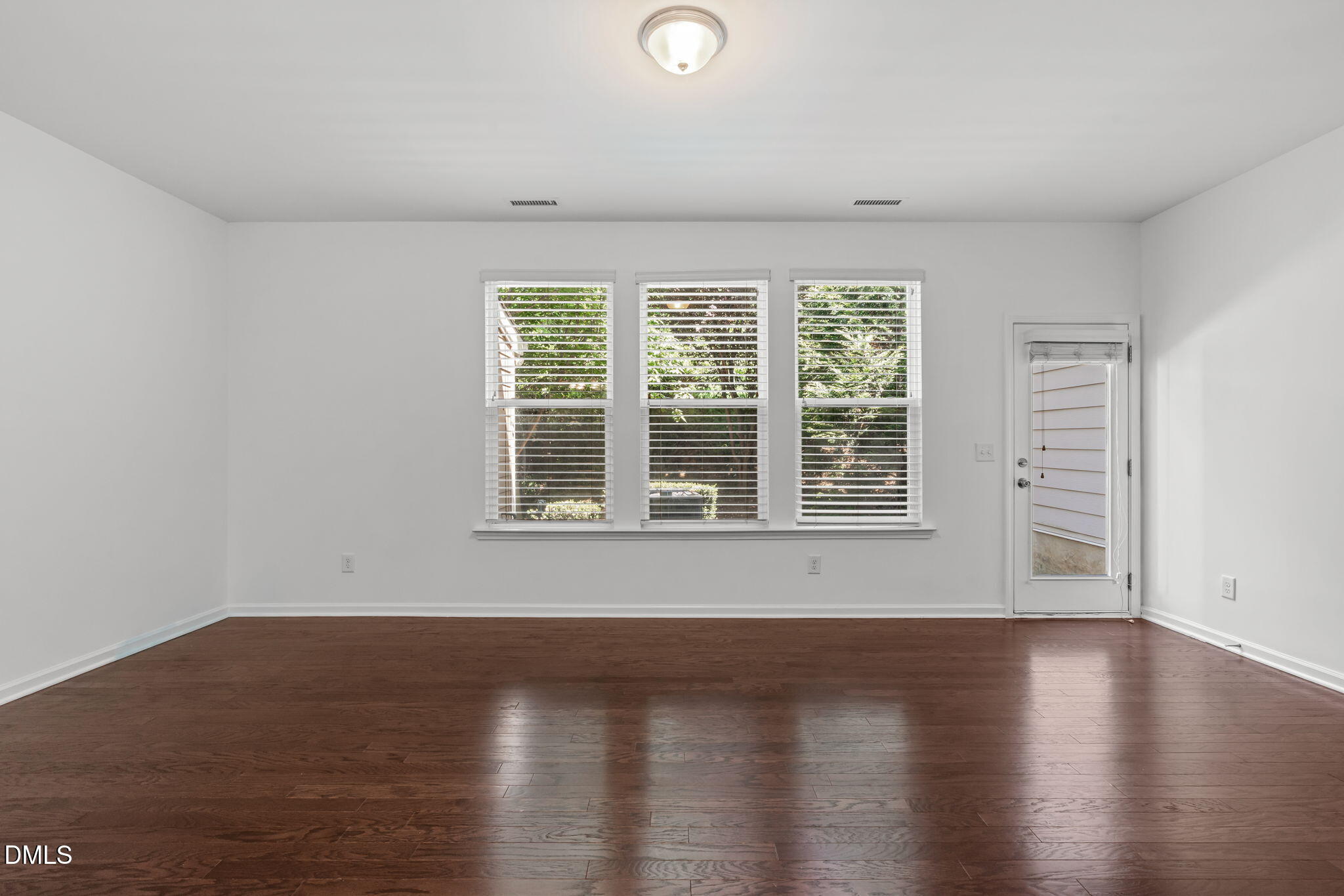 102 Ransomwood Drive Apex, NC 27539 - Photo 12 of 34 a view of wooden floor and windows in a room