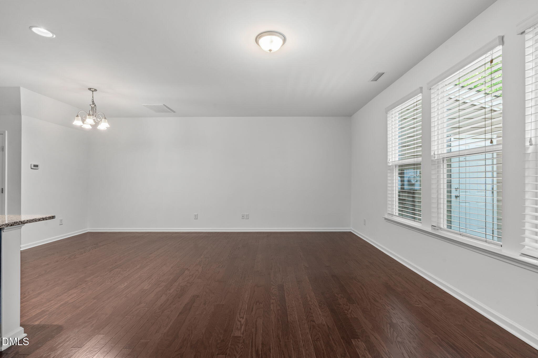 102 Ransomwood Drive Apex, NC 27539 - Photo 13 of 34 an empty room with wooden floor and windows