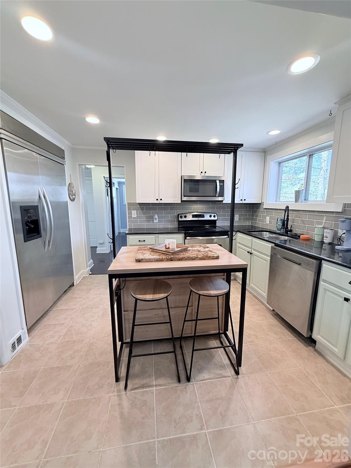 3743 Crosland Road Winston-Salem, NC 27106 - Photo 6 of 25 a kitchen with stainless steel appliances granite countertop a stove a sink a microwave a refrigerator and cabinets
