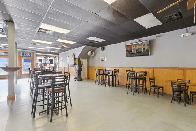 a dining hall with a lots of chairs and wooden floor