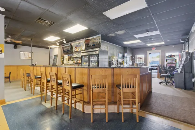 a hallway with painting on the wall and a large mirror