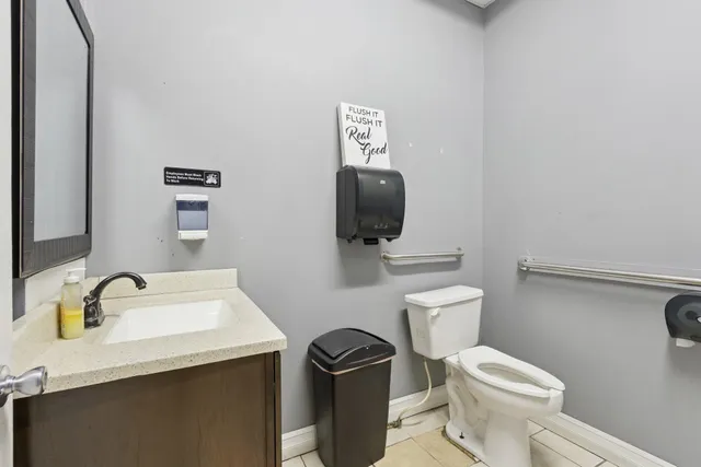 a living room with furniture a clock and a flat screen tv