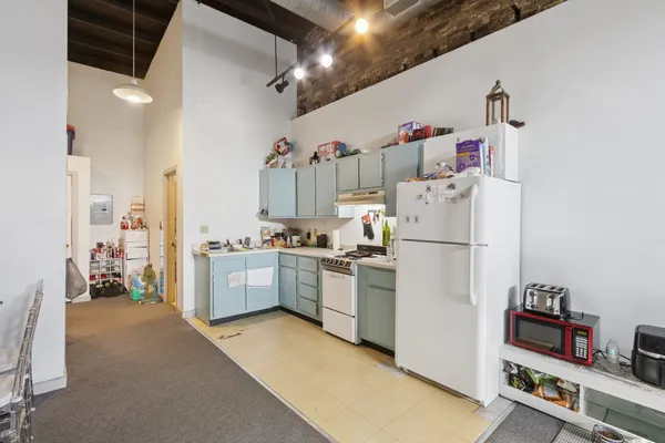 a kitchen with stainless steel appliances kitchen island granite countertop a sink and a refrigerator
