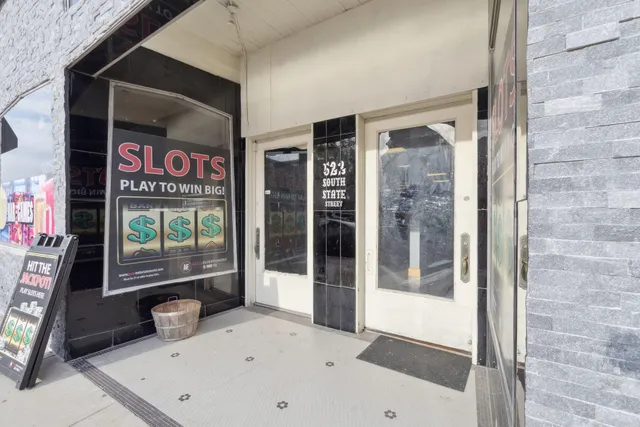 a dining hall with stainless steel appliances lots of wooden furniture a dining table and chairs with wooden floor