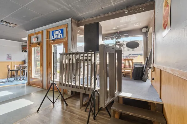 a dining hall with stainless steel appliances lots of wooden furniture a dining table and chairs with wooden floor