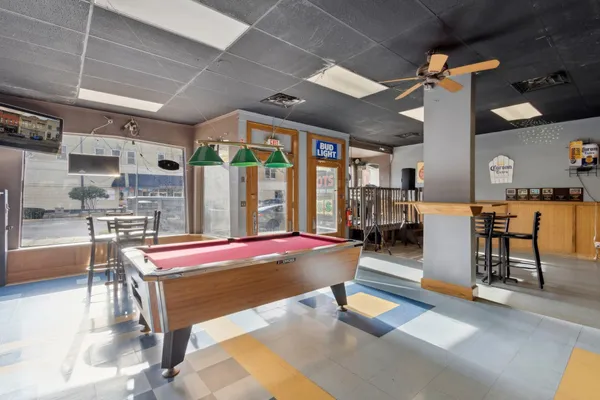 a living room with furniture pool table and a rug