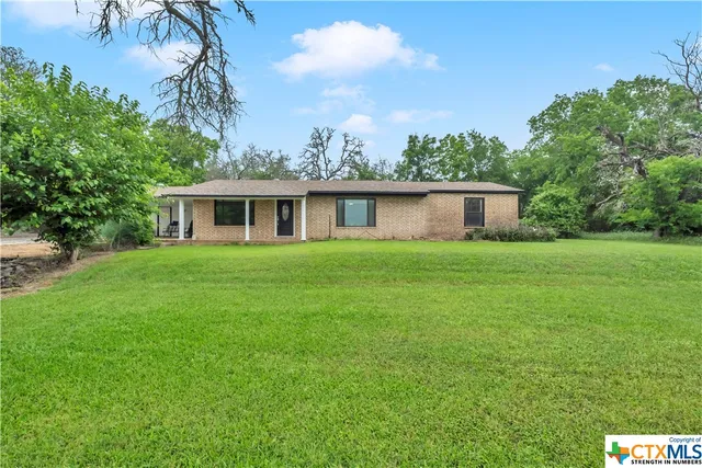 a house with a big yard and large trees