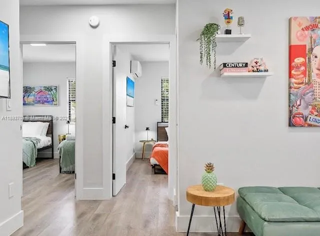 a view of a hallway with wooden floor and a livingroom