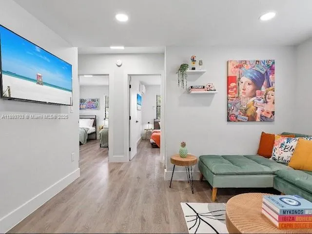 a living room with furniture and a wooden floor