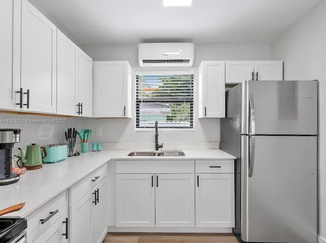 a kitchen with appliances a sink and a window