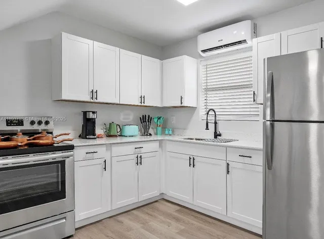 a kitchen with white cabinets and white appliances