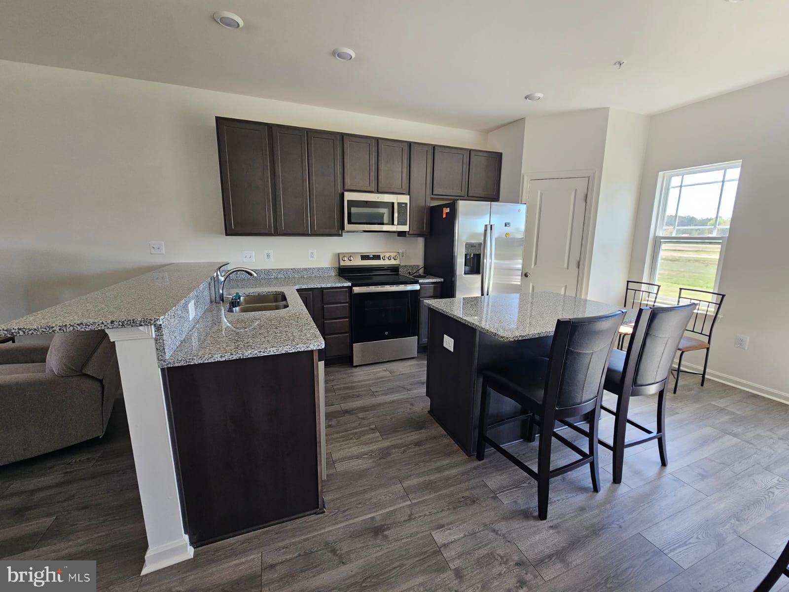 2506 Boeing Way Cambridge, MD 21613 - Photo 6 of 19 a kitchen with granite countertop a dining table and chairs