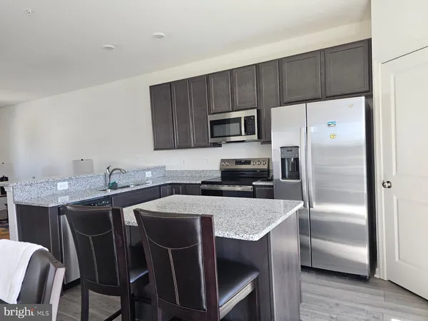 a kitchen with a table chairs refrigerator and microwave