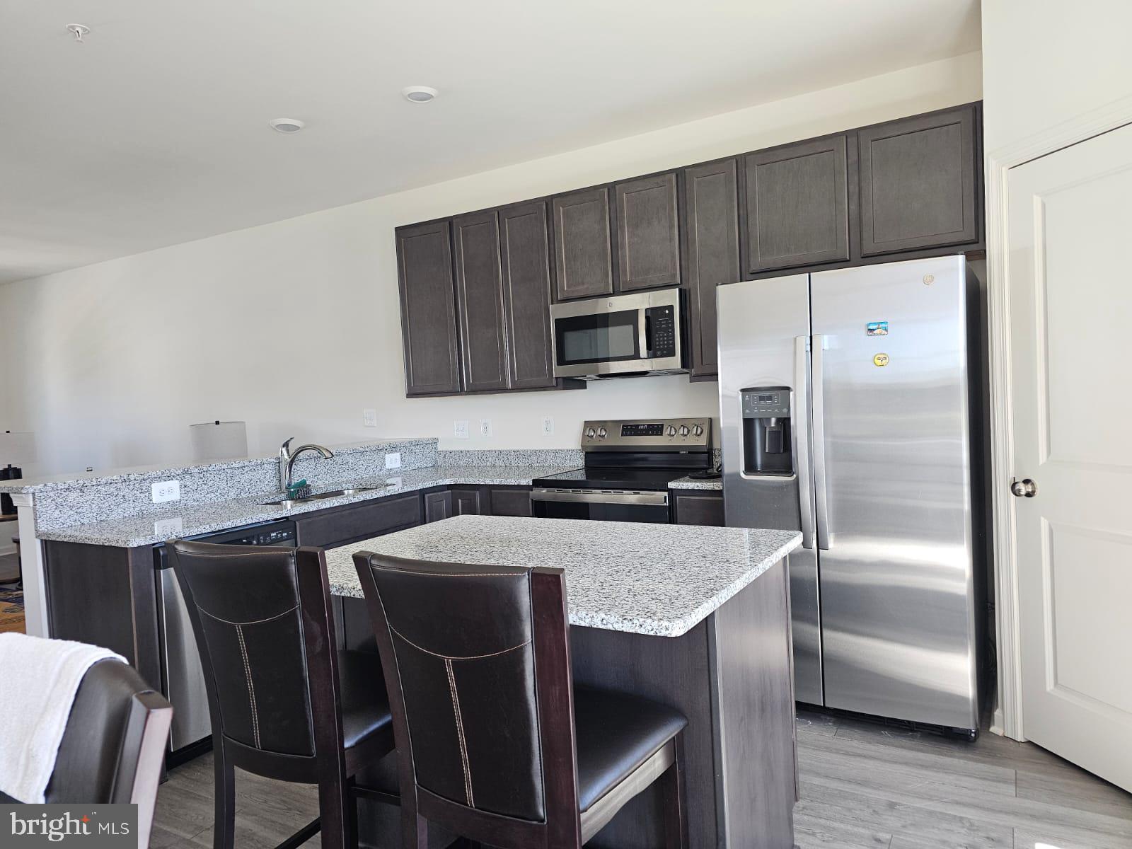 2506 Boeing Way Cambridge, MD 21613 - Photo 7 of 19 a kitchen with a table chairs refrigerator and microwave