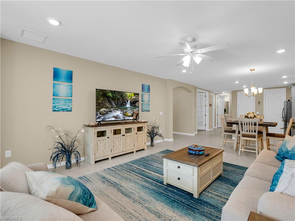 14695 Edgewater Circle Naples, FL 34114 - Photo 16 of 39 a living room with furniture and a flat screen tv