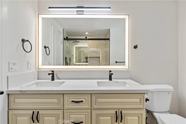 a bathroom with a sink a toilet and mirror
