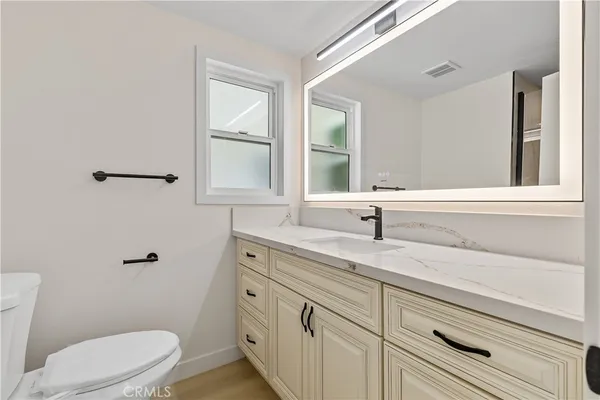 a bathroom with a sink a toilet and a window