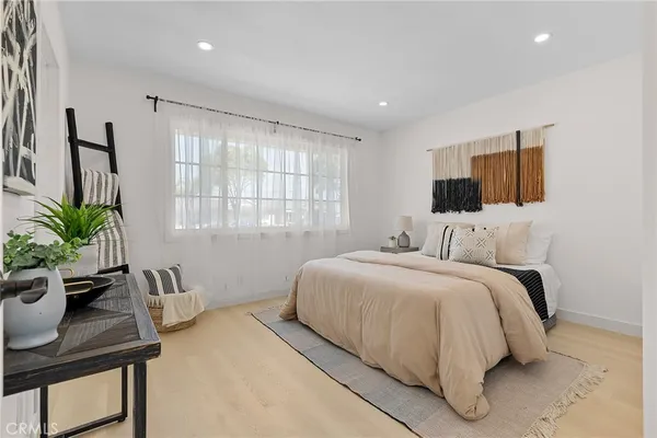 a bedroom with a bed window and potted plant on table