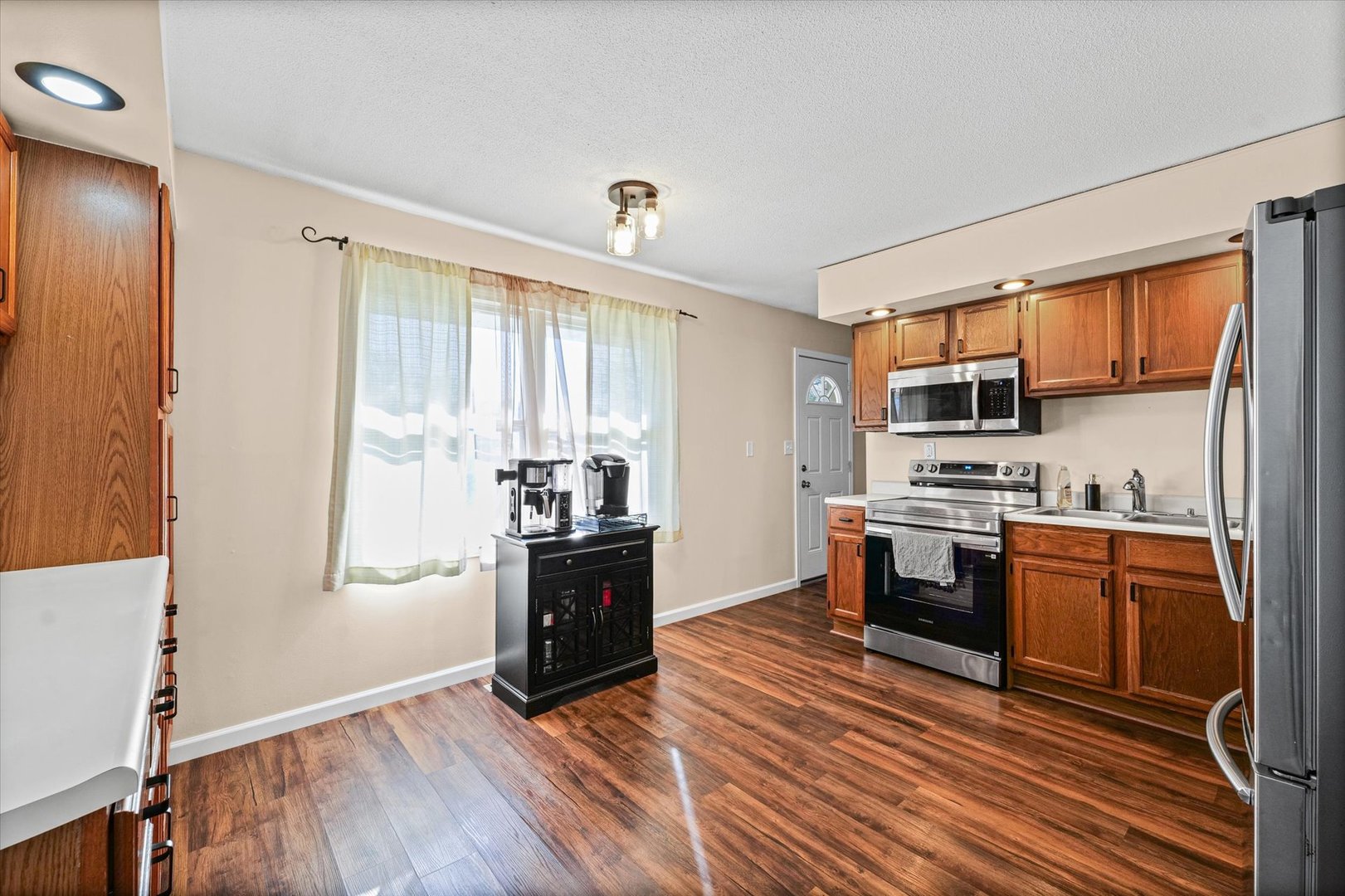 203 Valley Road Monticello, IL 61856 - Photo 8 of 25 a kitchen with stainless steel appliances granite countertop a refrigerator stove top oven and sink