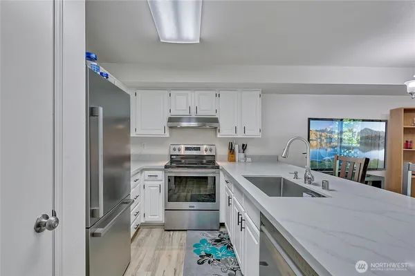a kitchen that has a sink cabinets counter space and stainless steel appliances