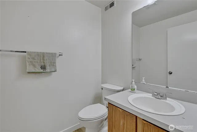 a bathroom with a granite countertop toilet a sink and mirror