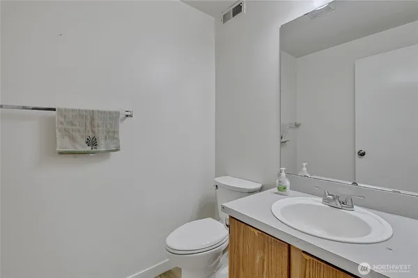 a bathroom with a granite countertop toilet a sink and mirror