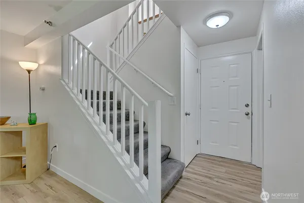 a view of a hallway with wooden floor and entryway