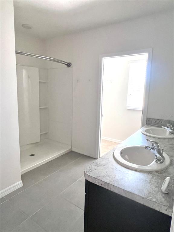 321 Blue Point Drive Ruskin, FL 33570 - Photo 11 of 18 a bathroom with a granite countertop sink a mirror and a shower