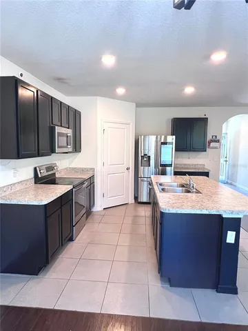 a kitchen with stainless steel appliances kitchen island granite countertop a sink and cabinets