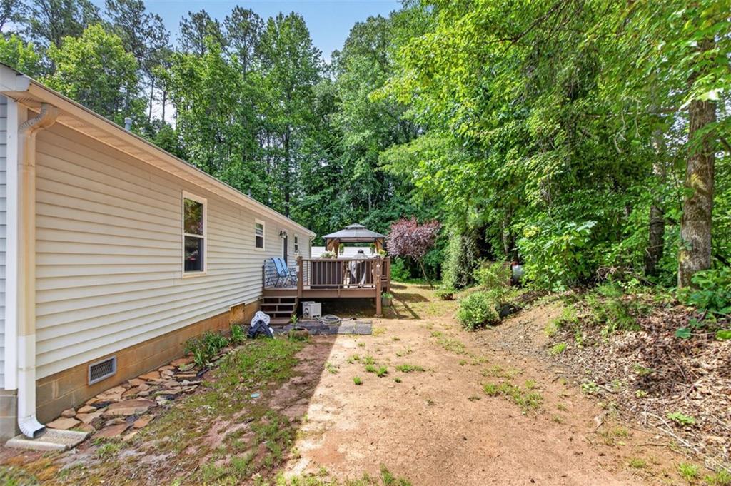 3771 Castleberry Road Cumming, GA 30040 - Photo 48 of 69 a backyard of a house with a large tree and wooden fence