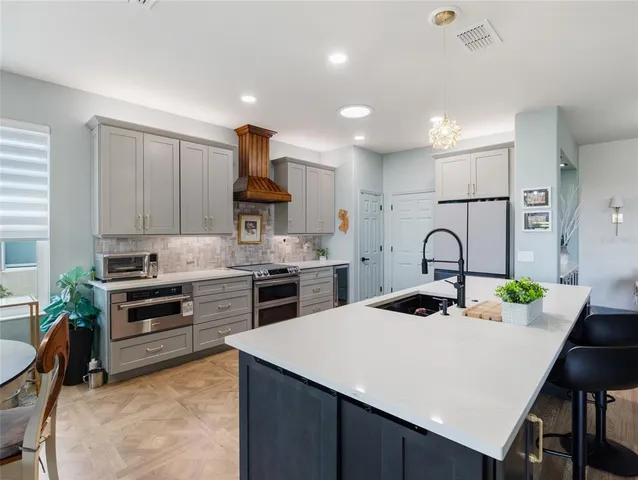 a kitchen with kitchen island a stove a table and chairs in it