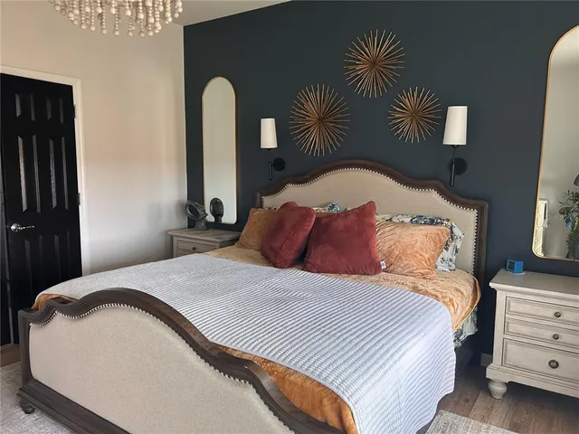 a bedroom with a bed and a painting on the wall