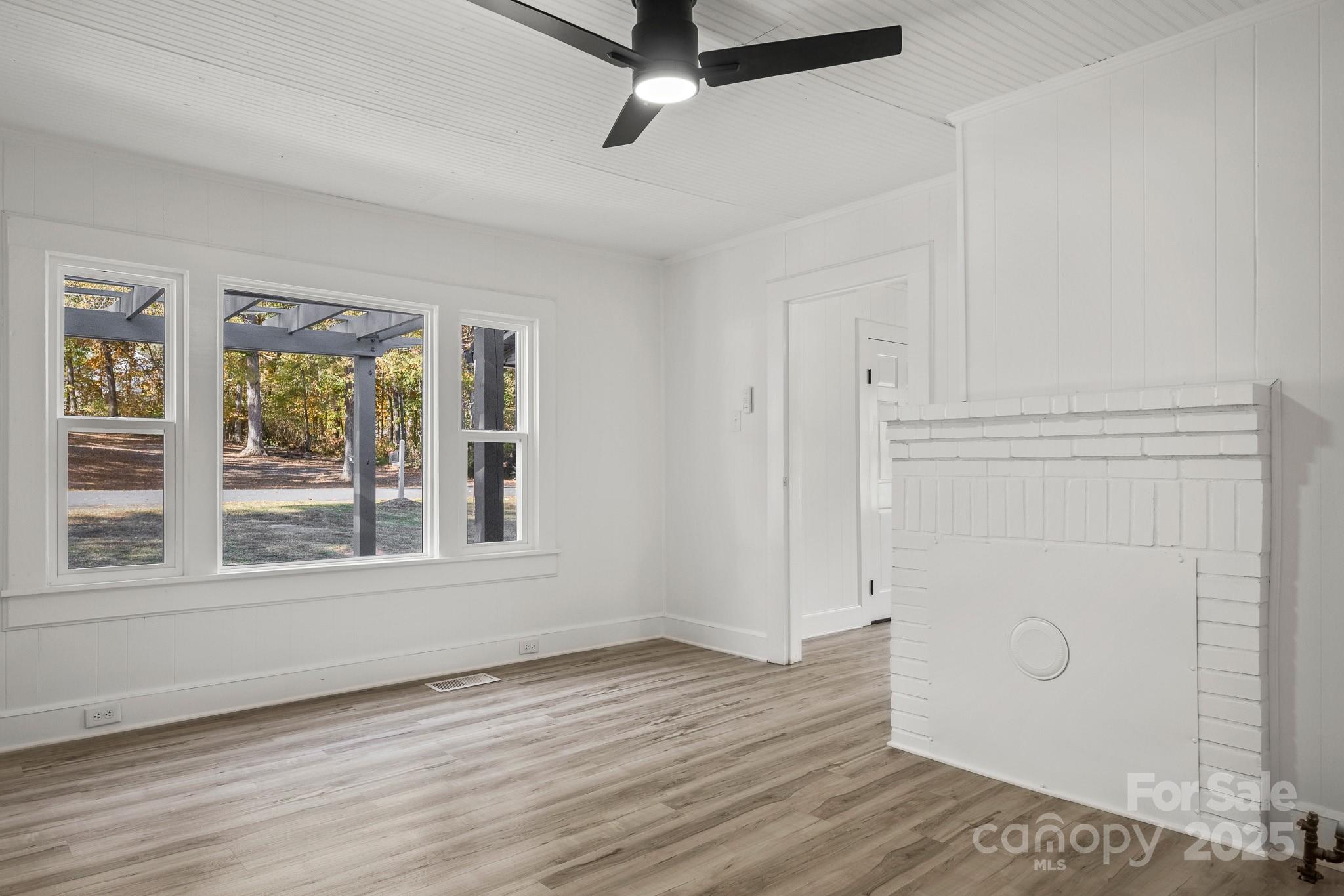 418 Charlotte Street York, SC 29745 - Photo 16 of 37 a view of an empty room with a window and wooden floor