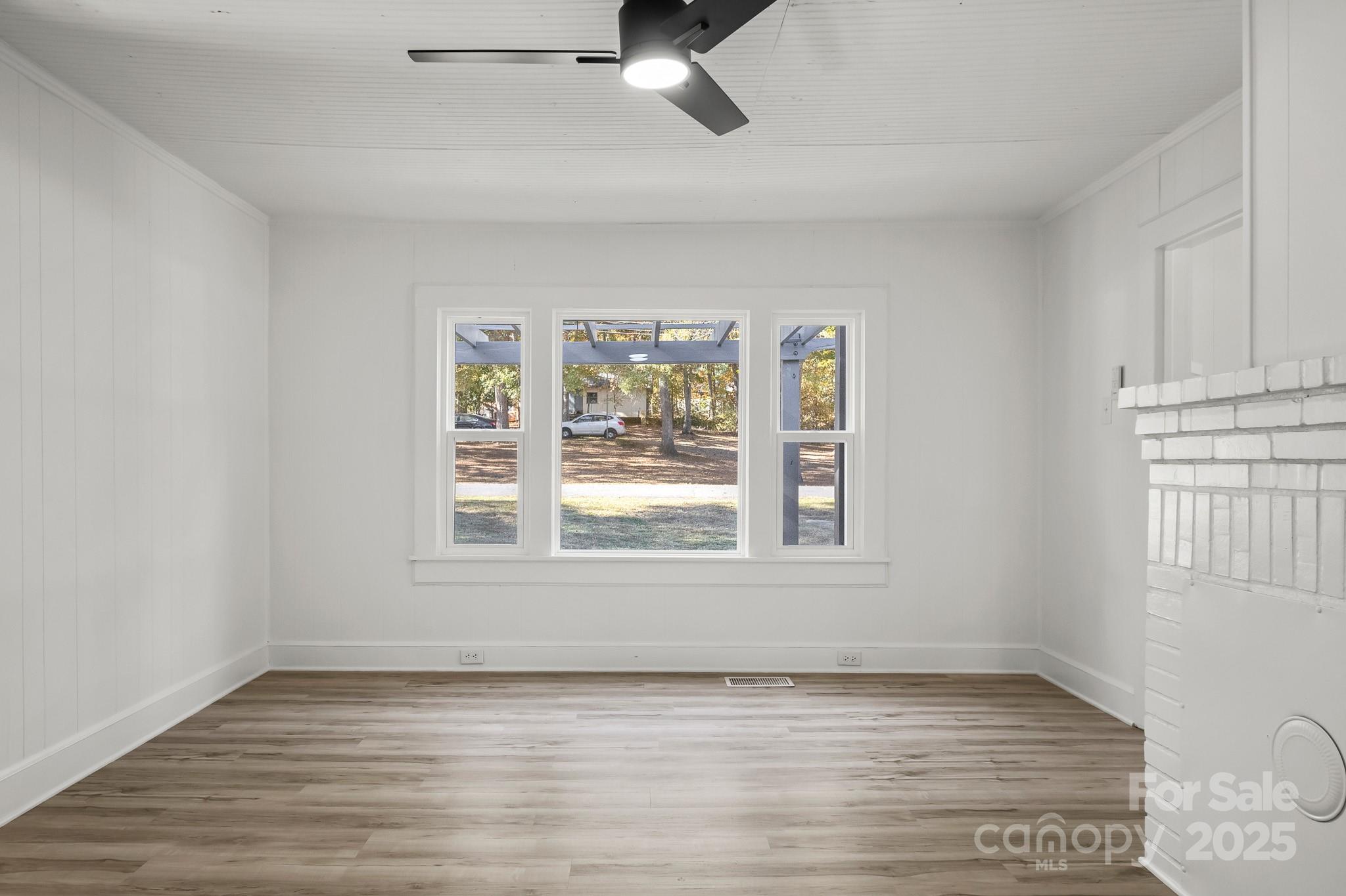 418 Charlotte Street York, SC 29745 - Photo 4 of 37 an empty room with wooden floor and windows