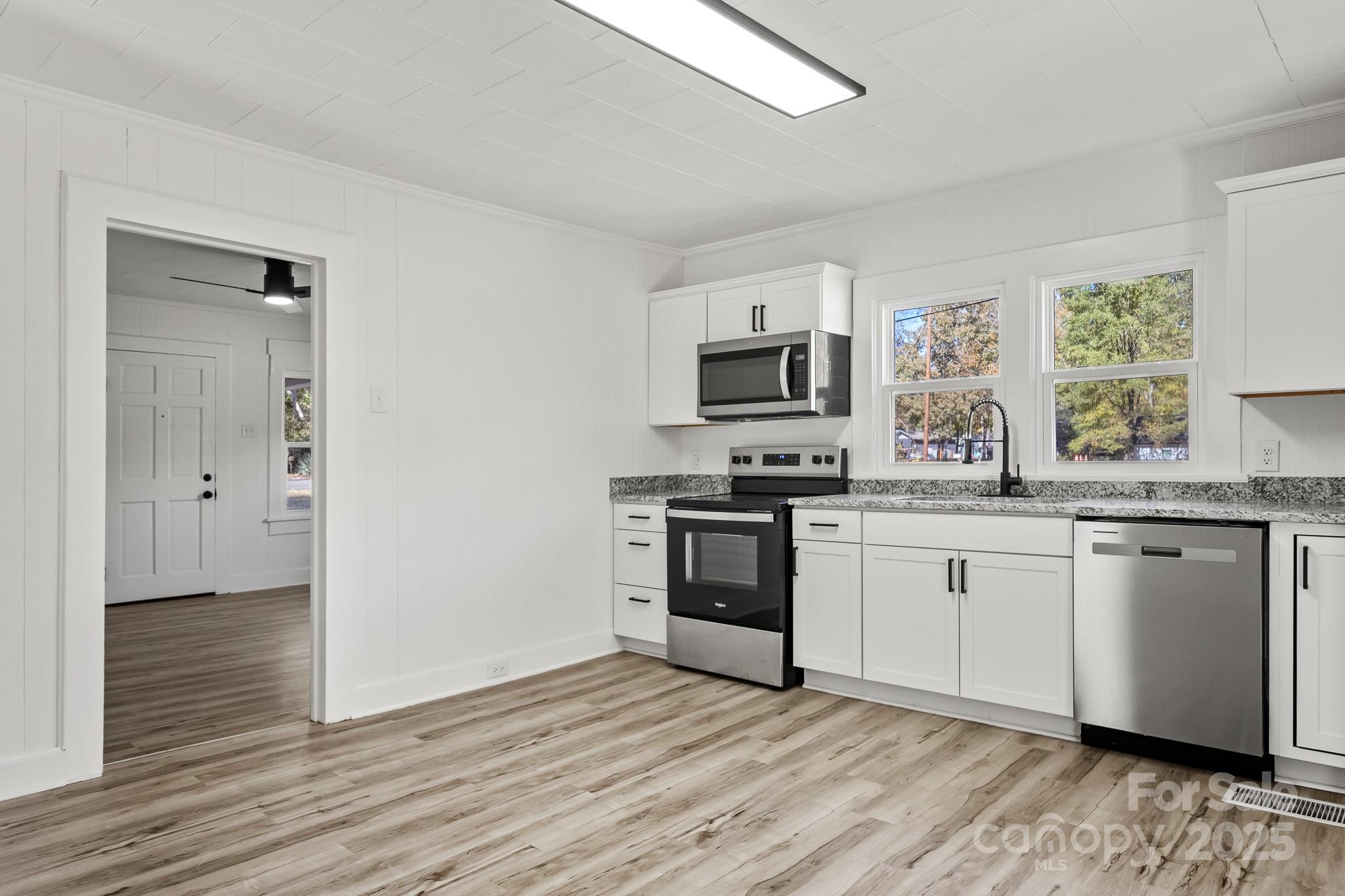 418 Charlotte Street York, SC 29745 - Photo 9 of 37 a kitchen with granite countertop a stove a sink and a microwave