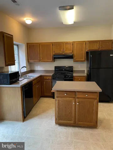 a kitchen with a stove a sink and a refrigerator