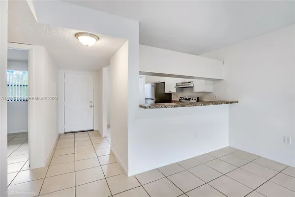 a kitchen with white cabinets a refrigerator and a sink
