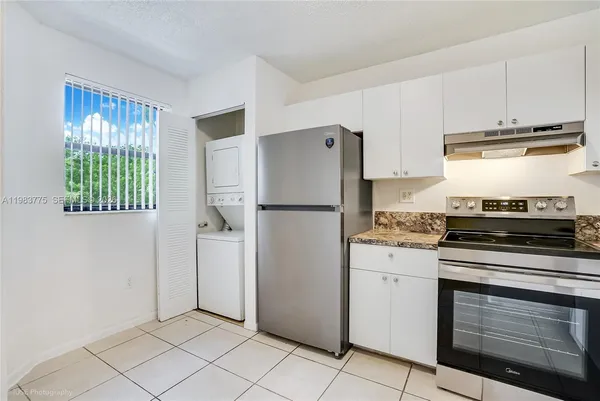 a kitchen with stainless steel appliances granite countertop a refrigerator sink and stove