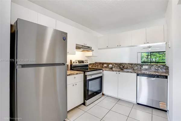 a kitchen with stainless steel appliances granite countertop a refrigerator and a stove