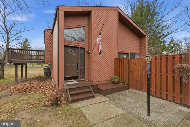 a view of a house with a door and wooden fence