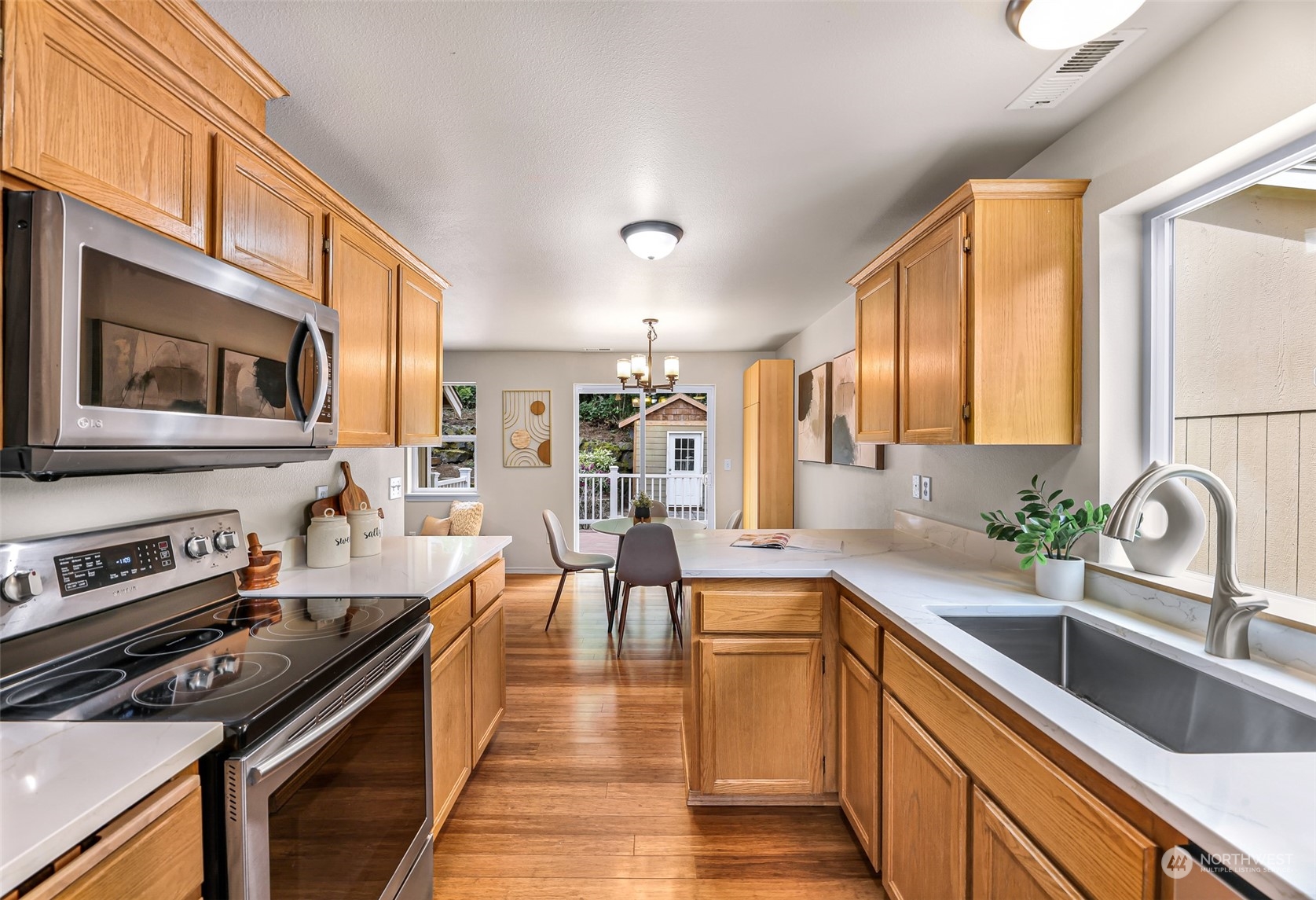 14423 Southeast 188 Way Renton, WA 98058 - Photo 11 of 40 a kitchen with stainless steel appliances a stove sink microwave and cabinets